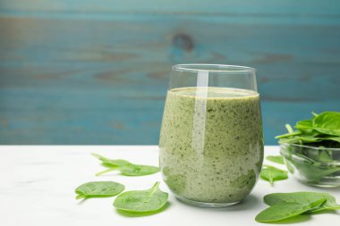 Lezzetli meyve püresi ve ıspanak yaprakları beyaz mermer masada, yakın plan. Metin için boşluk