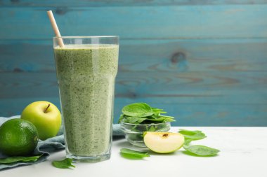 Lezzetli ıspanaklı smoothie ve beyaz mermer masada malzemeler, yakın plan. Metin için boşluk