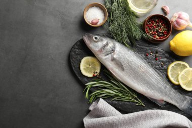Gri masadaki baharatlı taze çiğ deniz kabuğu balığı, yazı için düzlük ve boşluk. Deniz ürünleri lezzetleri.