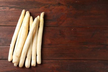 Ahşap masada bir sürü çiğ kuşkonmaz mızrağı var. Metin için boşluk