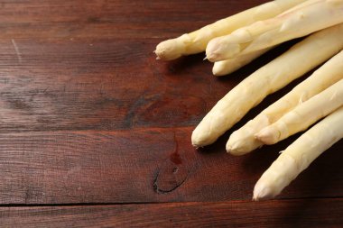 Ahşap masada bir sürü çiğ kuşkonmaz mızrağı, yakın plan, yazı için alan