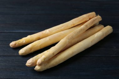 Siyah tahta masada çiğ beyaz kuşkonmaz mızrakları, yakın plan.