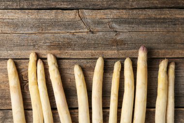 Tahta masaya çiğ beyaz kuşkonmaz mızrakları. Metin için boşluk