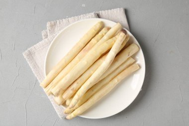 Gri desenli masa üzerinde çiğ beyaz kuşkonmaz mızrakları.