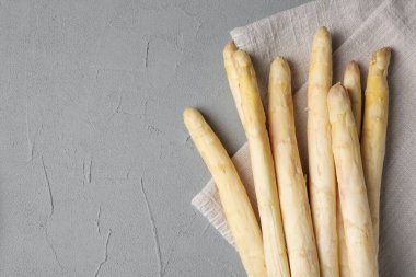 Gri desenli masa üzerinde çiğ beyaz kuşkonmaz mızrakları, üst manzara. Metin için boşluk