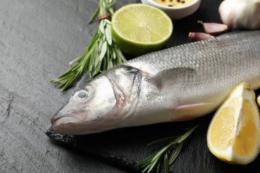 Siyah masada baharatlı taze çiğ deniz kabuğu, yakın plan. Balık ve deniz ürünleri lezzetleri