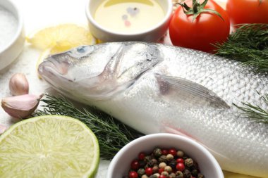 Beyaz masadaki baharatlı taze çiğ deniz kabuğu, yakın plan. Balık ve deniz ürünleri lezzetleri