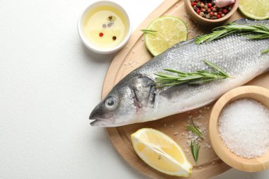 Beyaz masadaki baharatlı taze çiğ deniz kabuğu balığı, üst manzara ve yazı için yer. Deniz ürünleri lezzetleri.