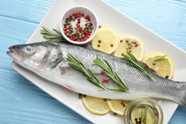 Mavi ahşap masadaki baharatlı taze çiğ deniz kabuğu. Balık ve deniz ürünleri lezzetleri