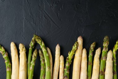 Siyah masada yeşil ve beyaz kuşkonmaz, düz yatıyordu. Metin için boşluk