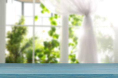 Odasında perde olan pencereye karşı boş ahşap masa