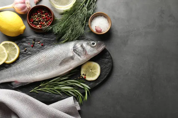 Gri masadaki baharatlı taze çiğ deniz kabuğu balığı, yazı için düzlük ve boşluk. Deniz ürünleri lezzetleri.