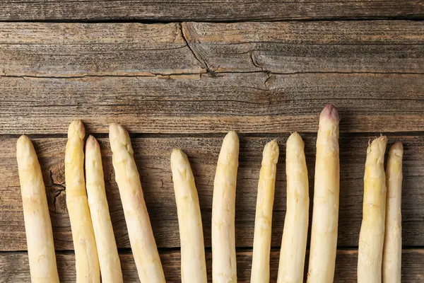 Tahta masaya çiğ beyaz kuşkonmaz mızrakları. Metin için boşluk