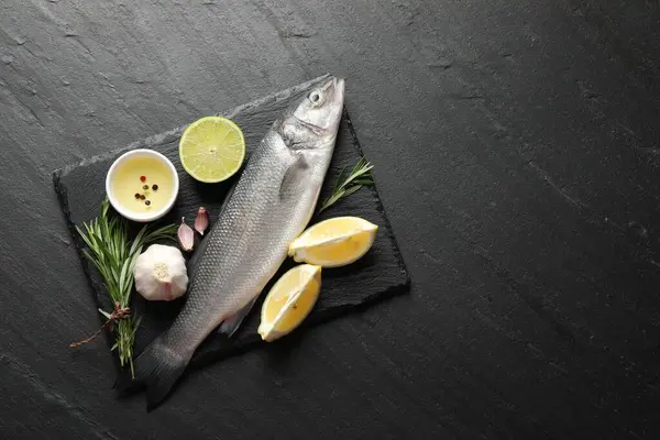 Siyah masadaki baharatlı taze çiğ deniz kabuğu balığı, üst görünüm ve metin için yer. Deniz ürünleri lezzetleri.