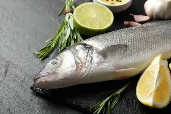 Siyah masada baharatlı taze çiğ deniz kabuğu, yakın plan. Balık ve deniz ürünleri lezzetleri