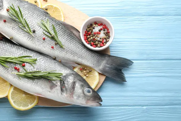 Mavi ahşap masadaki baharatlı taze çiğ deniz kabuğu balığı, üst manzara ve yazı için yer. Deniz ürünleri lezzetleri.