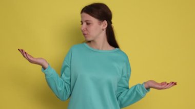 Sarı arka planda poz veren düşünceli genç kız.