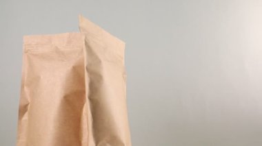 Açık gri arka planda dönen fermuar stand-up kesesi, yakın plan. Metin için boşluk