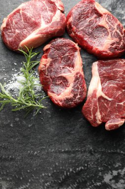 Koyu masa üzerinde çiğ et ve baharat parçaları, düz. Metin için boşluk