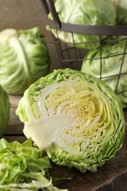 Taze kesilmiş ve bütün lahanalar ahşap masada, yakın plan.