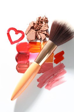 Beyaz arka planda farklı kozmetik ürünleri ve makyaj fırçası, düz konum