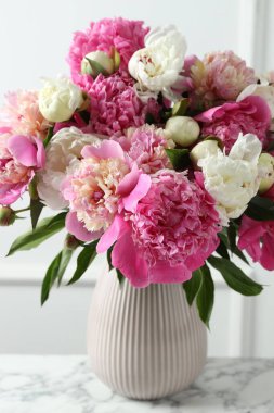 Güzel şakayıklar vazoda, beyaz mermer masanın üstünde, yakın plan.