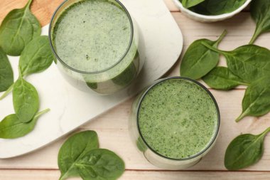 Lezzetli smoothie ve ıspanak yaprakları beyaz ahşap, düz yatar