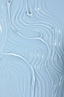 Açık mavi arkaplanda kozmetik ürün örneği, yakın plan