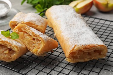Gri masada pudra şekeri ve nane şekerli lezzetli elmalı turtalar, yakın plan.