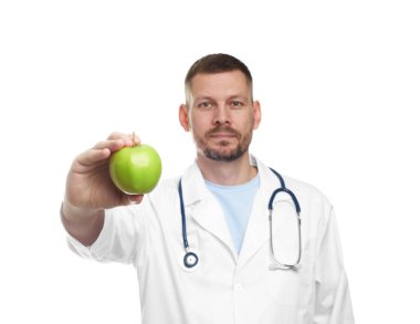 Beyaz arka planda yeşil elmalı ve steteskoplu beslenme uzmanı.