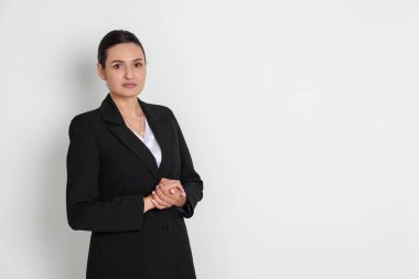 Hafif arka planda takım elbiseli kendine güvenen bir iş kadını. Metin için boşluk