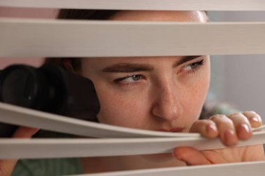 Paranoya işte. Pencereden içeri bakan, dürbünlü endişeli bir kadın.