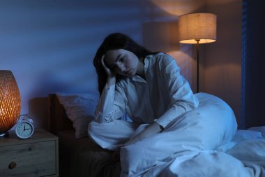 Evde yatağında uykusuzluk çeken hayal kırıklığına uğramış bir kadın.