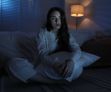 Evde yerde uykusuzluk çeken, yastıklı hayal kırıklığına uğramış bir kadın.