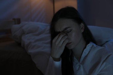 Evde uykusuzluk çeken, hayal kırıklığına uğramış bir kadın.