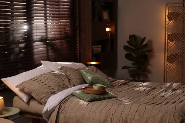 Yatak odasında güzel çarşafları olan rahat bir yatak.