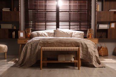 Yatak odasında güzel çarşafları olan rahat bir yatak.