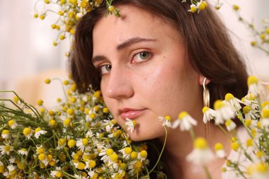 Kapalı alanda papatya çiçeği olan güzel bir kadının portresi.