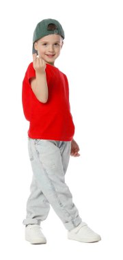 Beyzbol şapkalı küçük mutlu çocuk dans ediyor ve beyaz arka planda kalp hareketi gösteriyor.