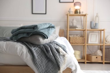 Yumuşak çarşafları olan rahat bir yatak ve şık bir odası olan bir raf. Ev tekstili