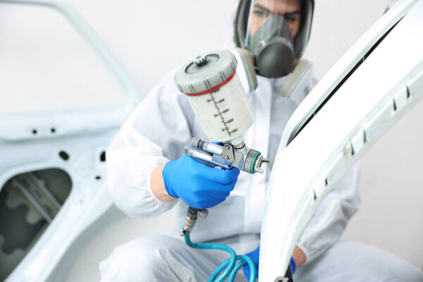 Работник покраски автомобиля в автомастерской, избирательный фокус