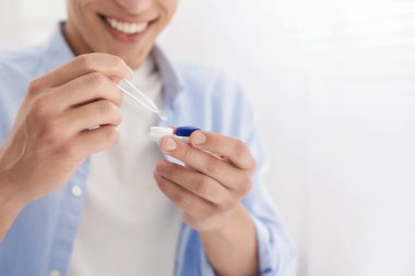 Adam kontakt lensleri evden çıkartıyor, yakın plan. Metin için boşluk