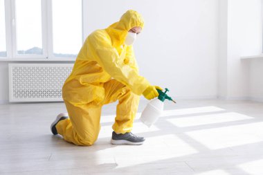 Koruyucu giysiler içinde böcek ilacı sıkan haşere kontrol görevlisi.