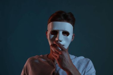 Anonimlik. Mavi arka planda maske takan adam