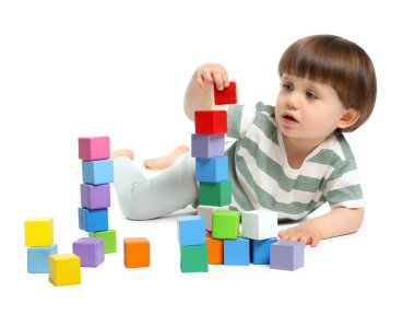 Beyaz arka planda renkli küplerle oynayan sevimli küçük çocuk.