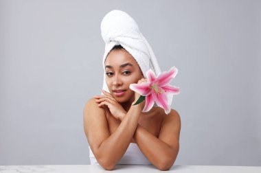 Gri arkaplandaki açık mermer masadaki spa tedavisinden sonra güzel Brezilyalı kadının portresi