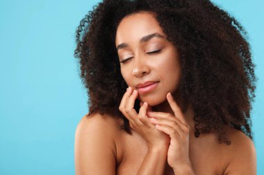 Açık mavi arka planda spa tedavisinden sonra güzel Brezilyalı kadın portresi