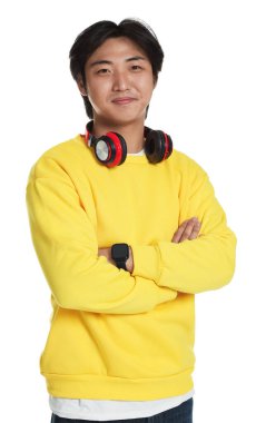 Beyaz arka planda kulaklığı olan yakışıklı Asyalı adamın portresi.