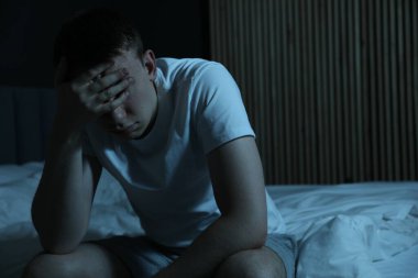 Yatakta uykusuzluk çeken hayal kırıklığına uğramış bir adam.