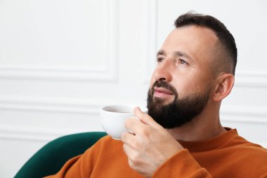 Uyum. Evdeki koltukta içki içen adam, yakın plan.